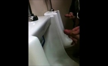 two slim dicks getting wanked at the urinals